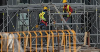 Équipe de construction en tenue de sécurité vérifiant les équipements et discutant des risques sur un chantier
