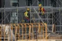 Équipe de construction en tenue de sécurité vérifiant les équipements et discutant des risques sur un chantier