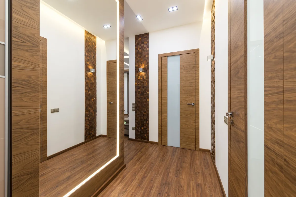 Grand miroir dans une entrée reflétant la lumière naturelle