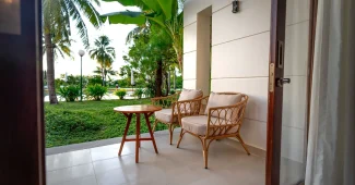 Terrasse aménagée avec mobilier de jardin élégant, coussins et plantes en pots sous le soleil