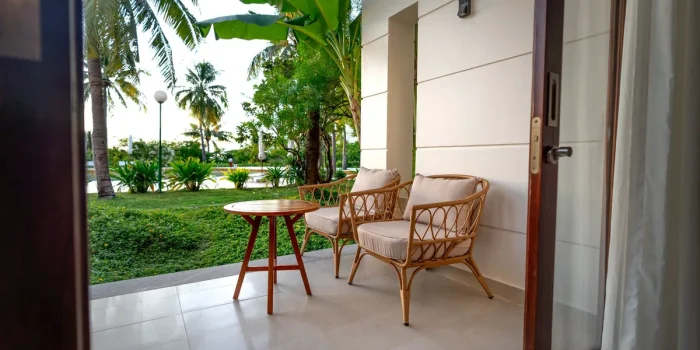 Terrasse aménagée avec mobilier de jardin élégant, coussins et plantes en pots sous le soleil