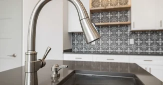 Versement d'eau chaude dans un évier de cuisine pour déboucher une canalisation