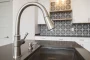 Versement d'eau chaude dans un évier de cuisine pour déboucher une canalisation