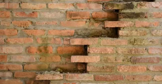 Mur en pierre ancienne d'une ferme avec poutres apparentes et détails architecturaux