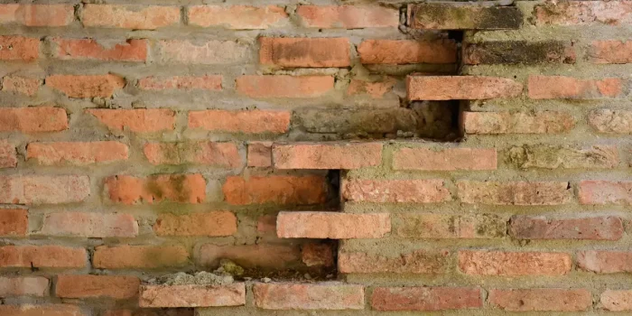 Mur en pierre ancienne d'une ferme avec poutres apparentes et détails architecturaux