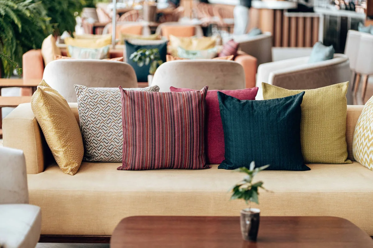 Coussin et plaid sur mobilier de terrasse pour créer du confort en soirée