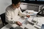 Main d'architecte esquissant des plans sur papier dans un éclairage studio doux
