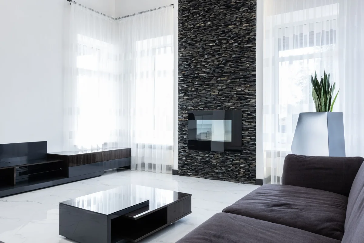 Salon contemporain avec surface minérale dominante, tapis texturé et mobilier aux lignes épurées