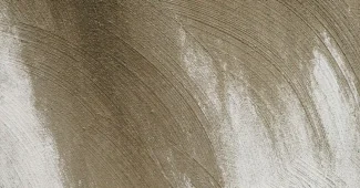 Intérieur minéral avec mur en pierre brute, sol en béton poli et jeux de lumière soulignant les textures