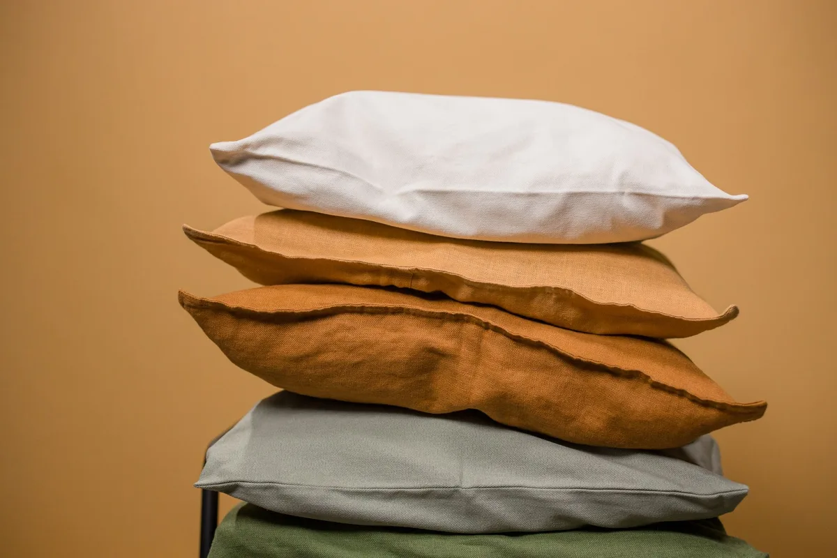 Détail de textiles et coussins en tons neutres montrant les variations de matière et de texture