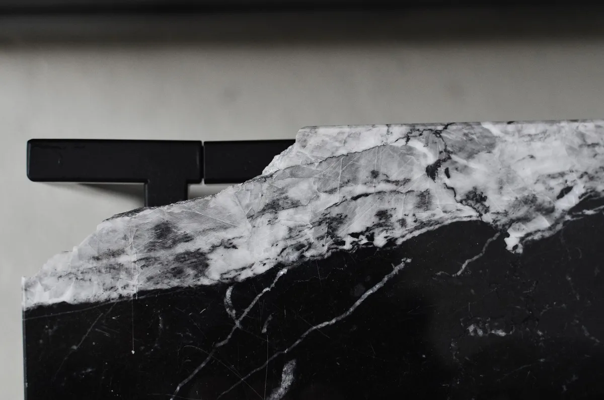 Surfaces minérales contrastées : marbre poli et finitions noires sophistiquées