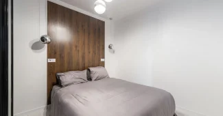 Intérieur moderne avec mur d'accent noir profond, éclairage directionnel et surfaces minérales contrastées