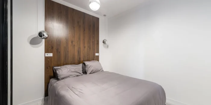 Intérieur moderne avec mur d'accent noir profond, éclairage directionnel et surfaces minérales contrastées