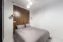 Intérieur moderne avec mur d'accent noir profond, éclairage directionnel et surfaces minérales contrastées