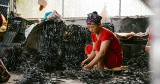 Matériaux de réemploi triés sur un établi d'atelier : textiles, fragments métalliques et résidus minéraux