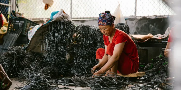 Matériaux de réemploi triés sur un établi d'atelier : textiles, fragments métalliques et résidus minéraux