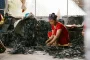 Matériaux de réemploi triés sur un établi d'atelier : textiles, fragments métalliques et résidus minéraux