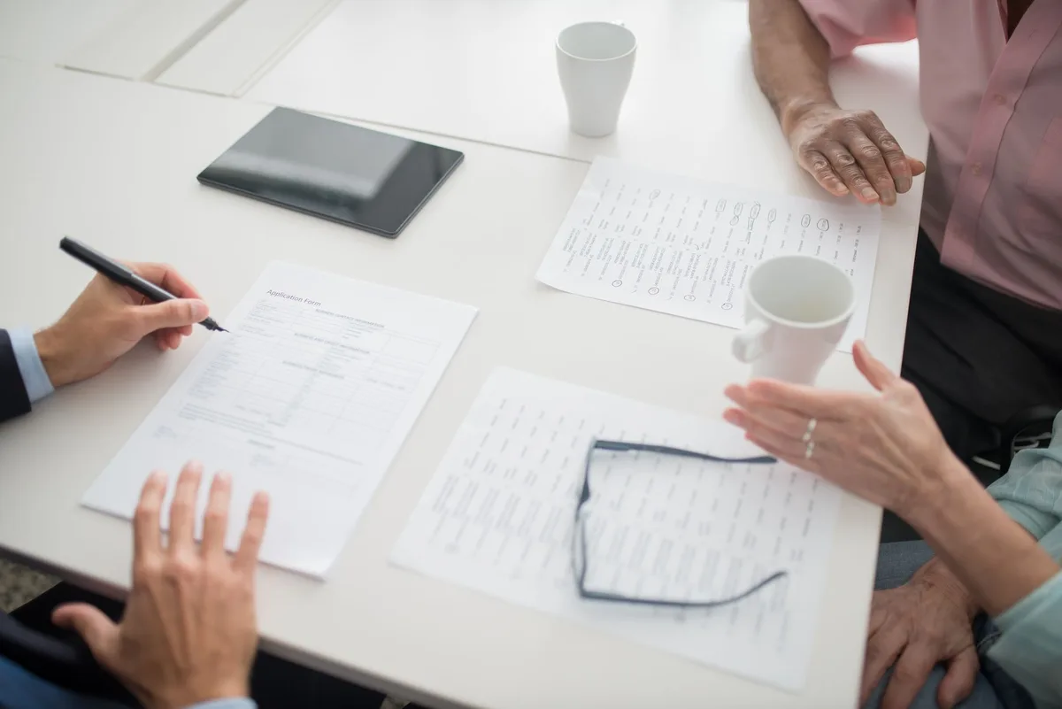 Documents d'assurance et comparaison de devis étalés sur un bureau de travail