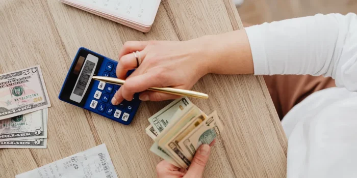 Facture d'électricité et calculatrice sur un bureau, mains tenant le document pour vérifier les coûts