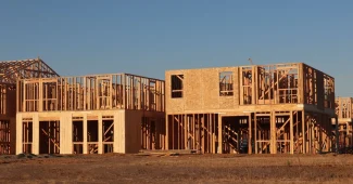 Chantier de construction d'une maison avec structure en bois et ouvriers en coordination