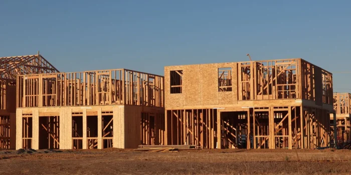 Chantier de construction d'une maison avec structure en bois et ouvriers en coordination