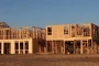 Chantier de construction d'une maison avec structure en bois et ouvriers en coordination