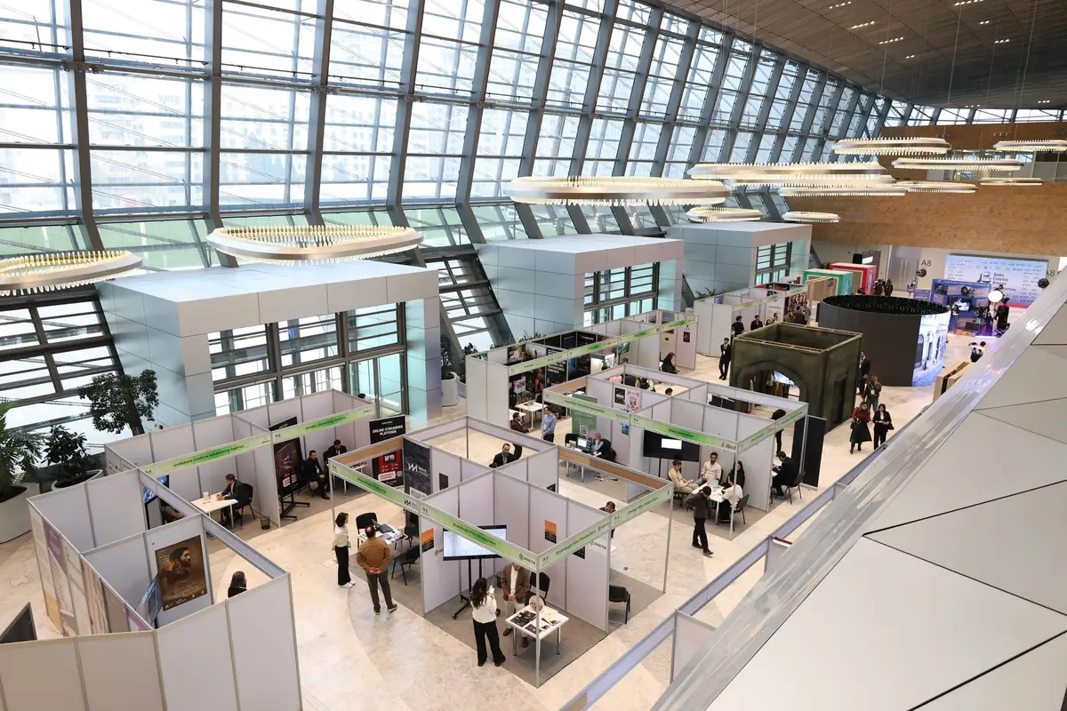 Visiteurs consultant un plan et des documents au salon, avec des produits d'aménagement en arrière-plan