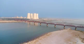 Fleuve au niveau exceptionnellement bas avec rives exposées et installations de refroidissement industrielles en arrière