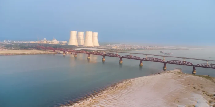 Fleuve au niveau exceptionnellement bas avec rives exposées et installations de refroidissement industrielles en arrière
