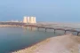 Fleuve au niveau exceptionnellement bas avec rives exposées et installations de refroidissement industrielles en arrière