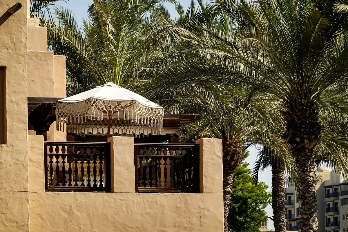 Parasol déporté compact sur un petit balcon avec table et chaises