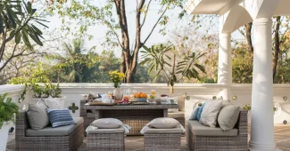 Terrasse décorée avec coussins, plantes et mobilier bohème dans la lumière dorée