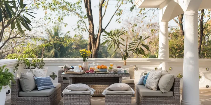 Terrasse décorée avec coussins, plantes et mobilier bohème dans la lumière dorée