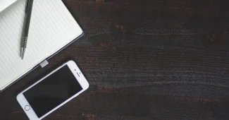 Mains tenant un téléphone affichant un flux Instagram cohérent avec des notes créatives