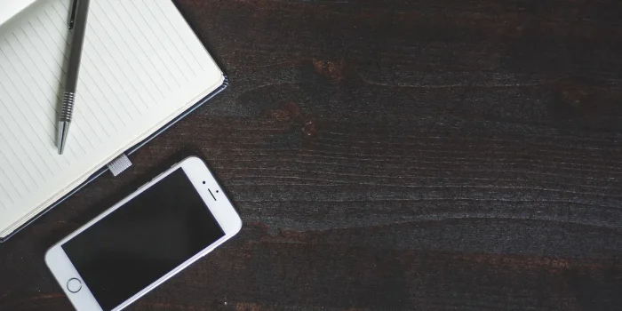 Mains tenant un téléphone affichant un flux Instagram cohérent avec des notes créatives