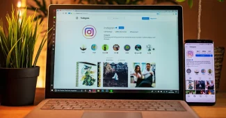 Mains anonymes tenant un smartphone au-dessus de croquis UX et d'un ordinateur portable