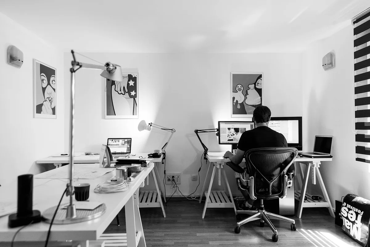 Bureau bien éclairé avec lampe directionnelle et écran à hauteur des yeux
