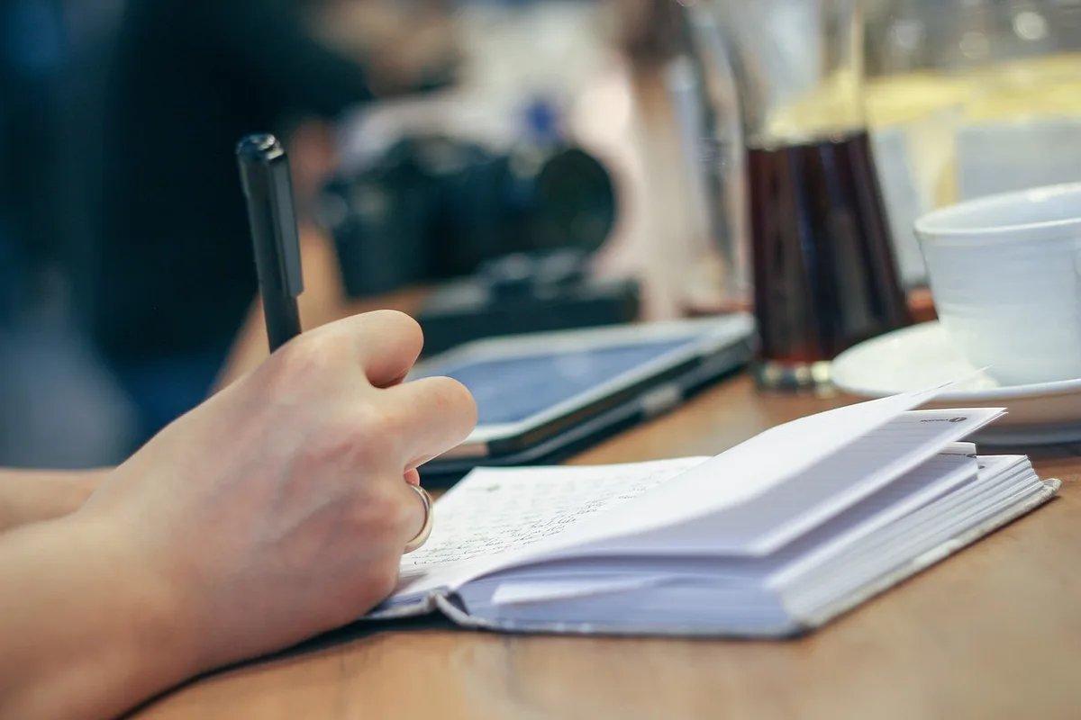 Mains organisant un dossier de demande avec calendrier et budget