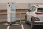 Intérieur moderne avec borne de recharge électrique, pompe à chaleur et panneaux solaires visibles par la fenêtre