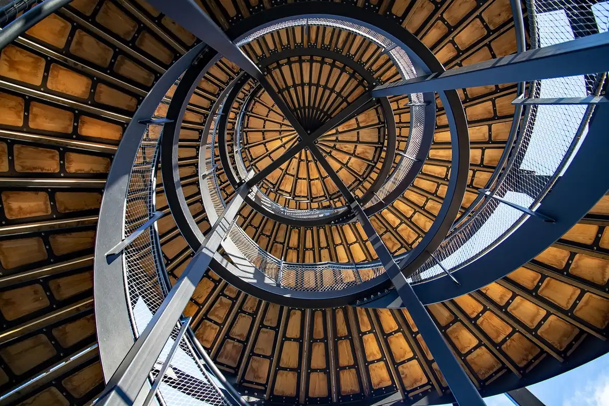 Escalier en colimaçon avec marches en bois et garde-corps discret