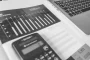Feuilles d'avis d'impôt, calculatrice et tasse sur une table en plein jour