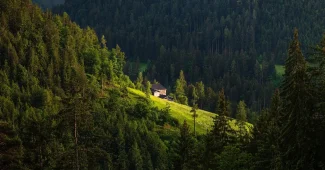 Maison semi-enterrée intégrée dans une colline avec murs en pierre et toit végétalisé
