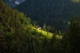 Maison semi-enterrée intégrée dans une colline avec murs en pierre et toit végétalisé