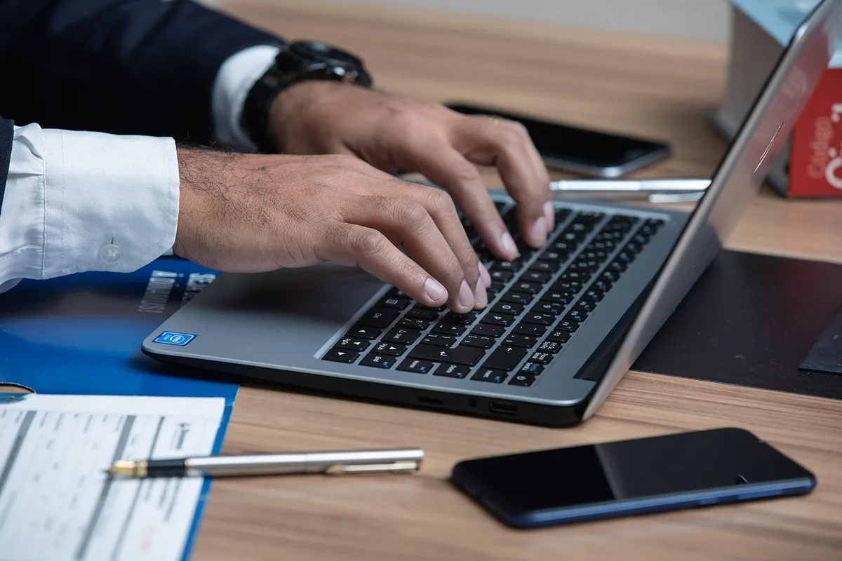 Personne vérifiant des factures et relevés de consommation sur un bureau en plein jour