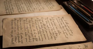 Personne recherchant la signification d'un acronyme sur un ordinateur avec des documents papier et une loupe