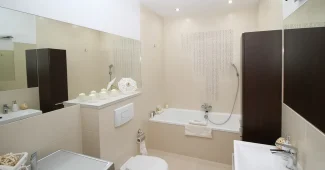Cour intérieure parisienne pavée avec portes vitrées ouvertes sur un salon lumineux et végétation
