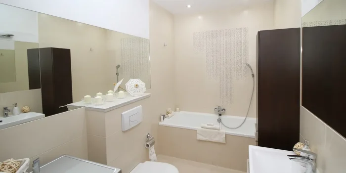 Cour intérieure parisienne pavée avec portes vitrées ouvertes sur un salon lumineux et végétation
