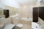 Cour intérieure parisienne pavée avec portes vitrées ouvertes sur un salon lumineux et végétation