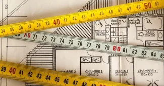 Bureau d'architecte en journée avec plans et échantillons de matériaux sur la table