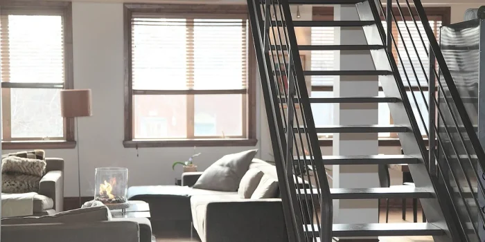 Coin salon lumineux avec canapé, fauteuil et banc près d'une grande fenêtre